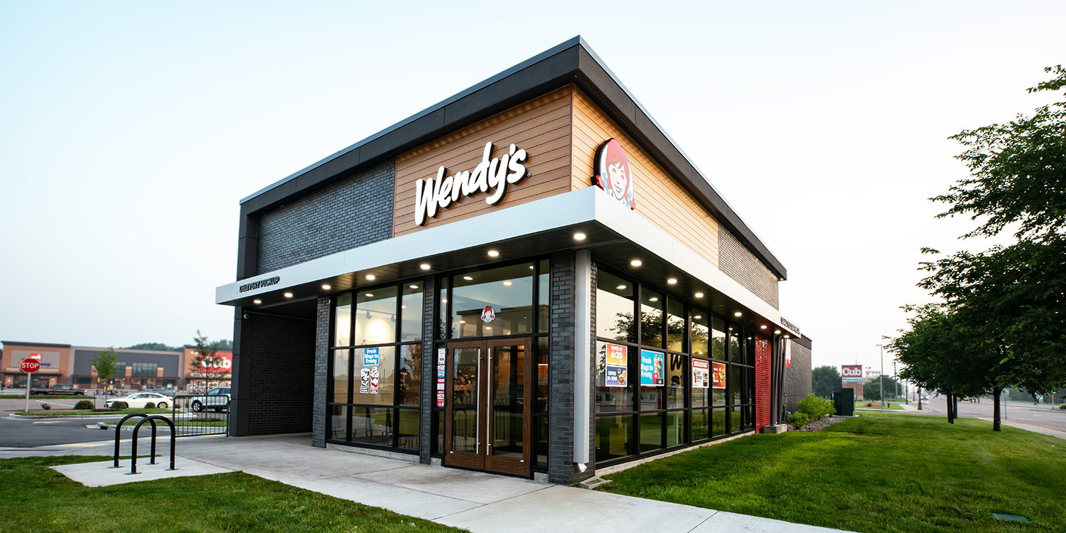 Exterior restaurant showing dark grey bricks, wood paneling, and Wendy's logo